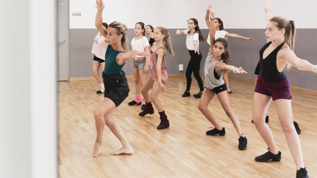 Esther Bosch enseñando danza a un grupo de niñas en su escuela, trabajando coordinación, expresión corporal y confianza.