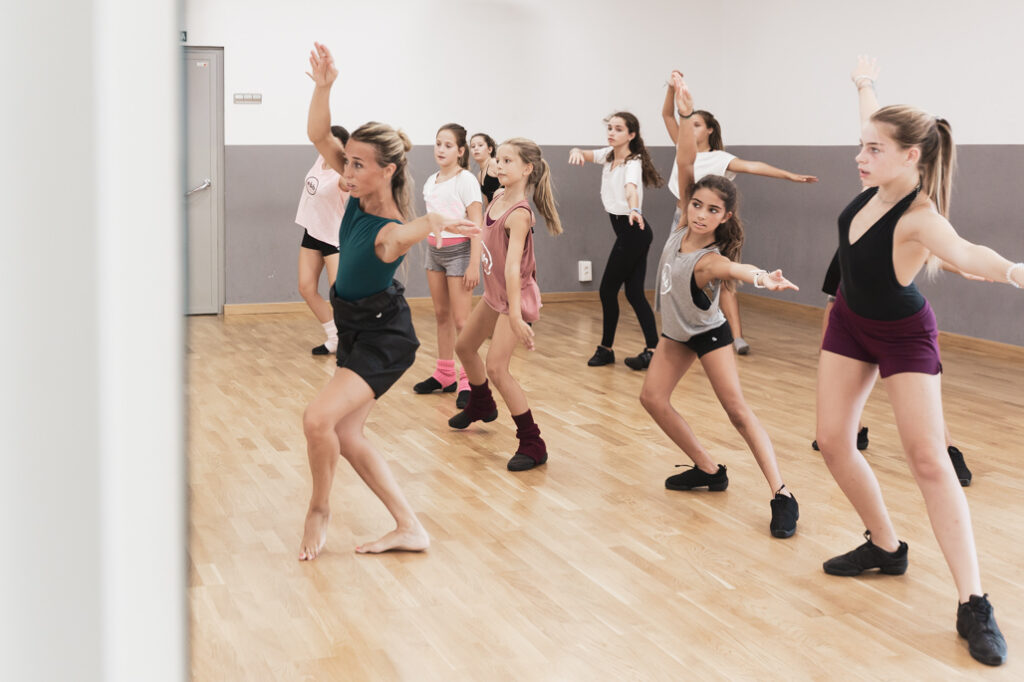 Esther Bosch enseñando danza a un grupo de niñas en su escuela, trabajando coordinación, expresión corporal y confianza.
